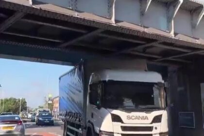 A trucker wedged his HGV under a 15ft 9in bridge near South Ruislip station, west London, despite clear height warnings. Traffic built up as locals filmed the aftermath.