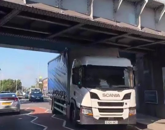 A trucker wedged his HGV under a 15ft 9in bridge near South Ruislip station, west London, despite clear height warnings. Traffic built up as locals filmed the aftermath.