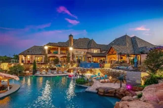Luxurious Oklahoma City mansion for sale at $17M, featuring 8 bedrooms, 16 baths, a bowling alley, dance floor, bars, and a stunning 70,000-gallon pool. Ultimate entertainment estate.