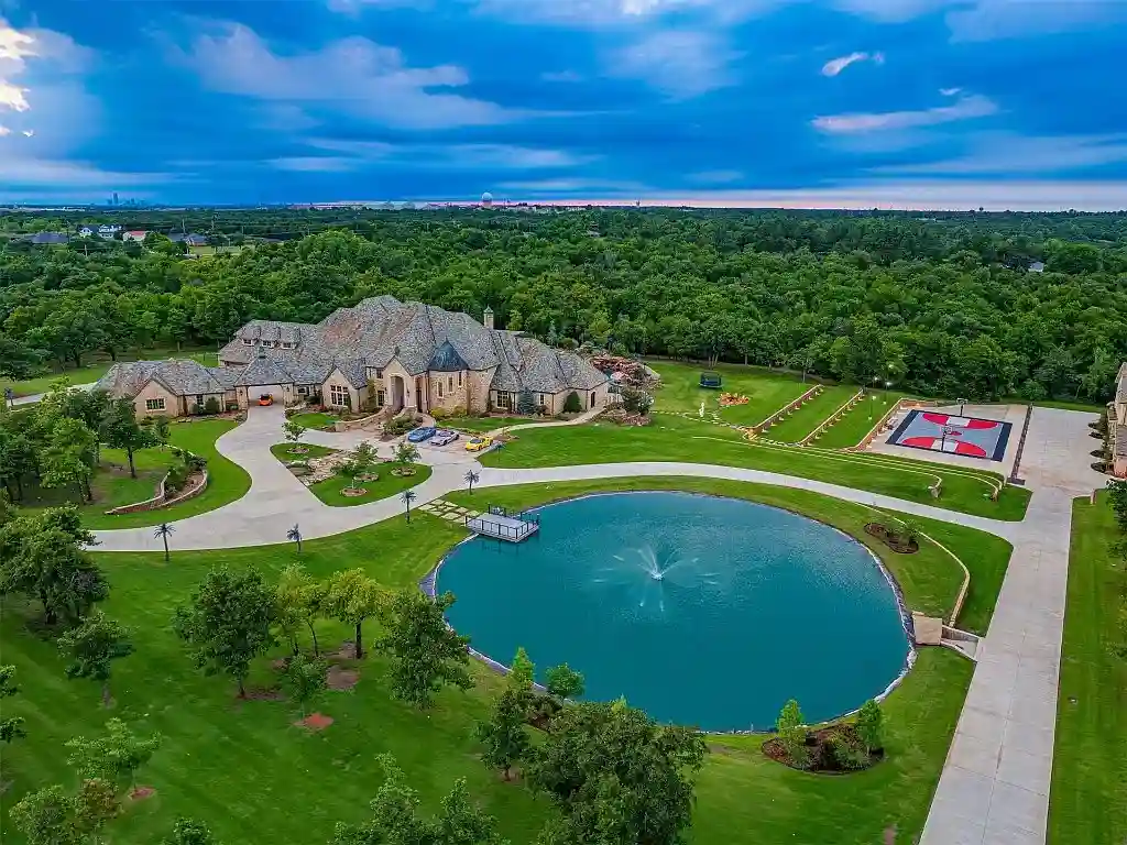 Luxurious Oklahoma City mansion for sale at $17M, featuring 8 bedrooms, 16 baths, a bowling alley, dance floor, bars, and a stunning 70,000-gallon pool. Ultimate entertainment estate.