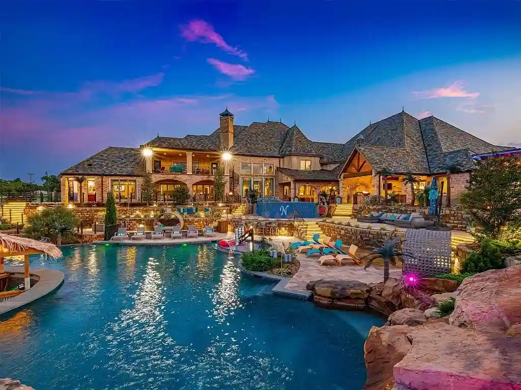 Luxurious Oklahoma City mansion for sale at $17M, featuring 8 bedrooms, 16 baths, a bowling alley, dance floor, bars, and a stunning 70,000-gallon pool. Ultimate entertainment estate.