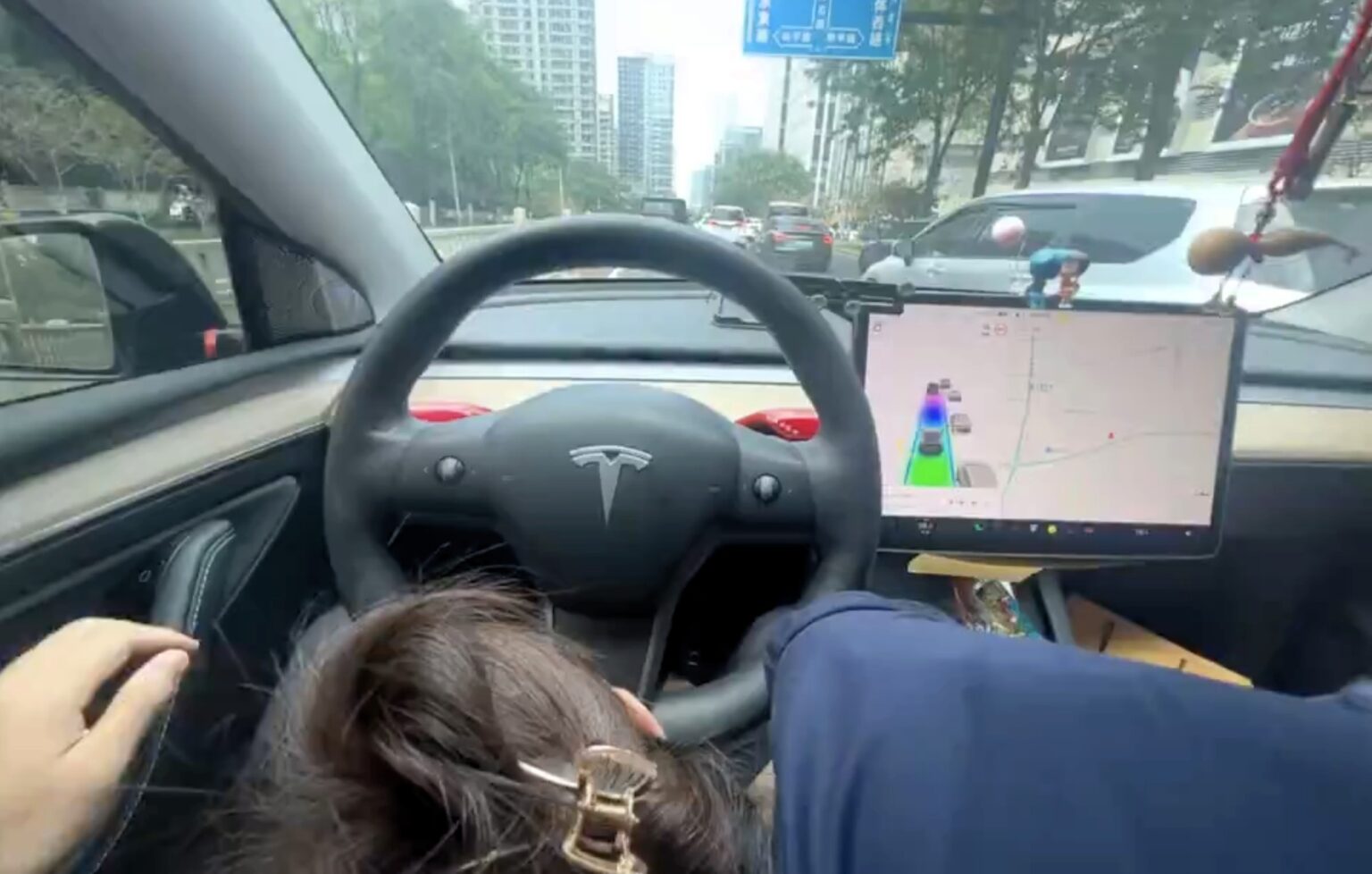 A man filmed himself in a Tesla as a woman appeared to perform a sex act while driving on a busy road in China, sparking outrage. The incident has raised safety concerns.