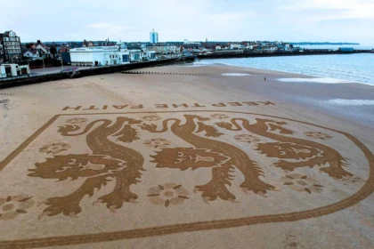 Artist Fred Brown created a huge England football badge on Bridlington beach to inspire Euro 2024 stars, captured by drone before the tide swept it away.