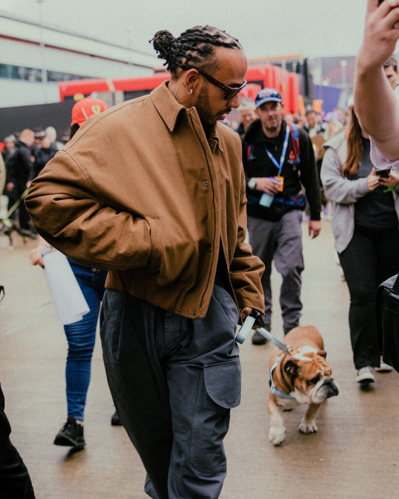 F1 star Lewis Hamilton pampers his Bulldog, Roscoe, with a £167.99 mini SUV toy, complete with a personalized number plate, sparking mixed reactions from fans.