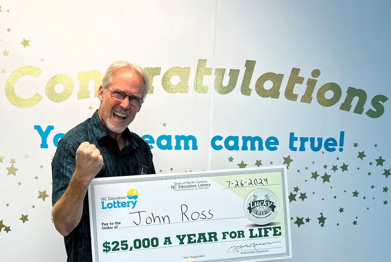 Lottery winner John Ross bags £300,000 by closing his eyes and pointing at random numbers. He chose a lump sum prize on his wife's birthday, beating 1 in 1.8 million odds.