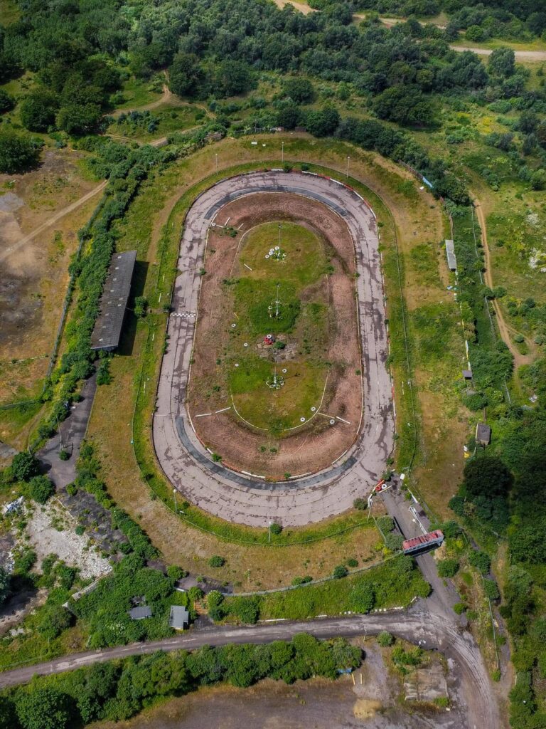 An explorer discovered the abandoned Arena Essex racetrack, now reclaimed by nature. Once a bustling site, it closed in 2018. Fans recall fond memories of the track.