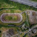 An explorer discovered the abandoned Arena Essex racetrack, now reclaimed by nature. Once a bustling site, it closed in 2018. Fans recall fond memories of the track.