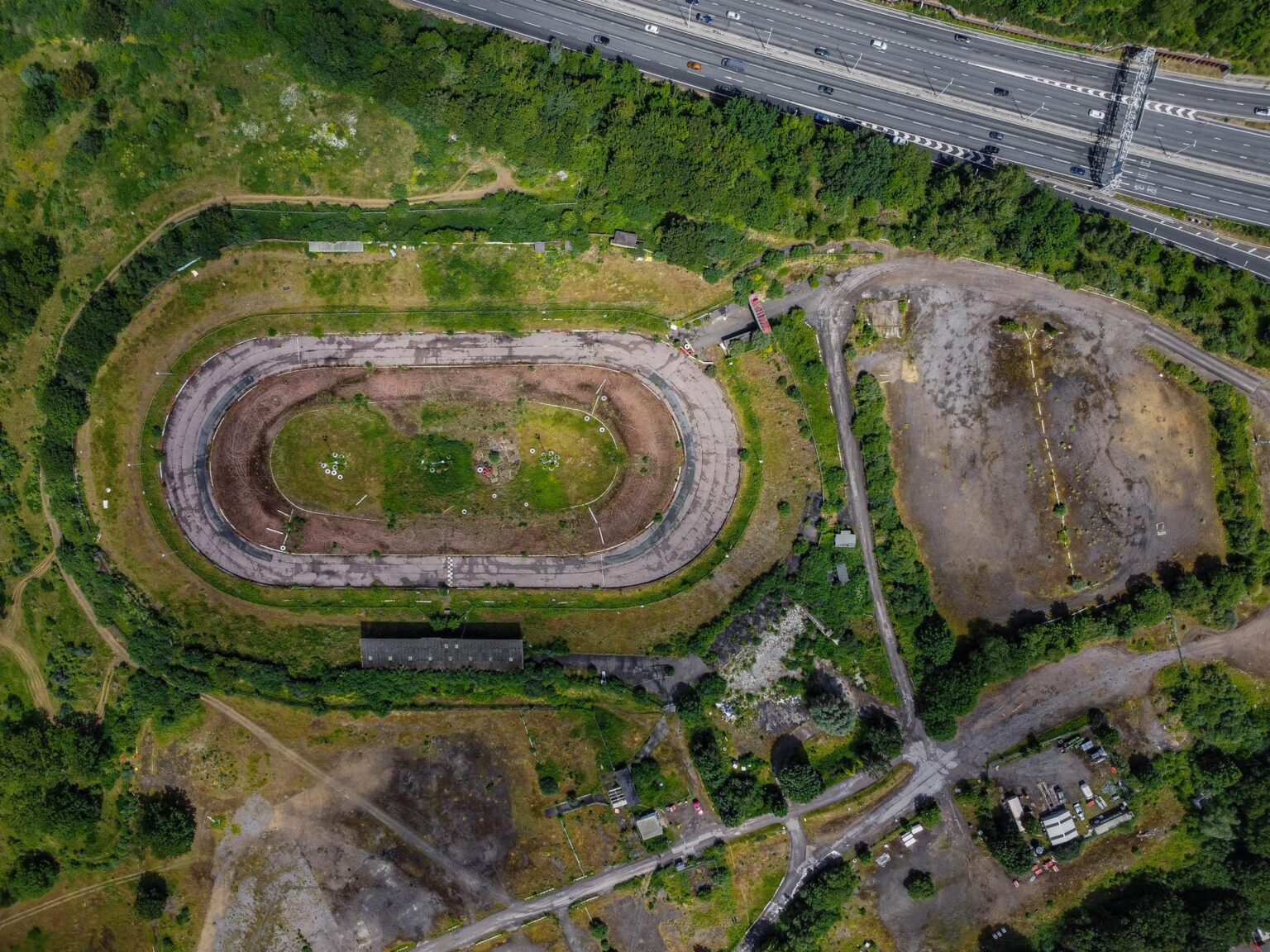 An explorer discovered the abandoned Arena Essex racetrack, now reclaimed by nature. Once a bustling site, it closed in 2018. Fans recall fond memories of the track.