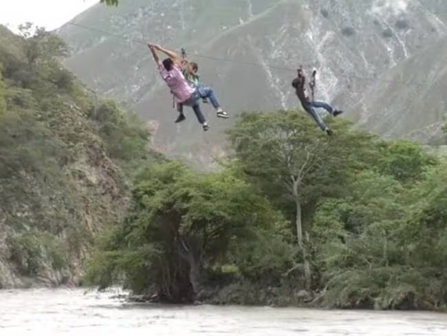 Pupils in Buraga, Colombia, cross a rickety suspension bridge over a crocodile-infested river daily to reach school, while others in Molagavita use a dangerous zipline across the Chicamocha River.