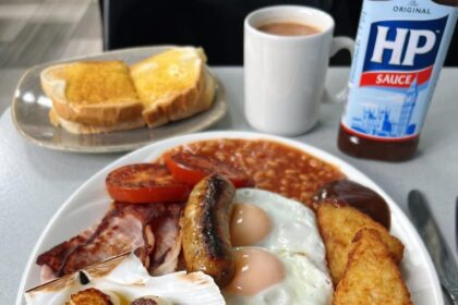 Diehard fry-up fans criticize Billingsgate Cafe's Full English breakfast with scallops, sparking debate over the unique £13 dish featuring traditional items and scallops in garlic butter.