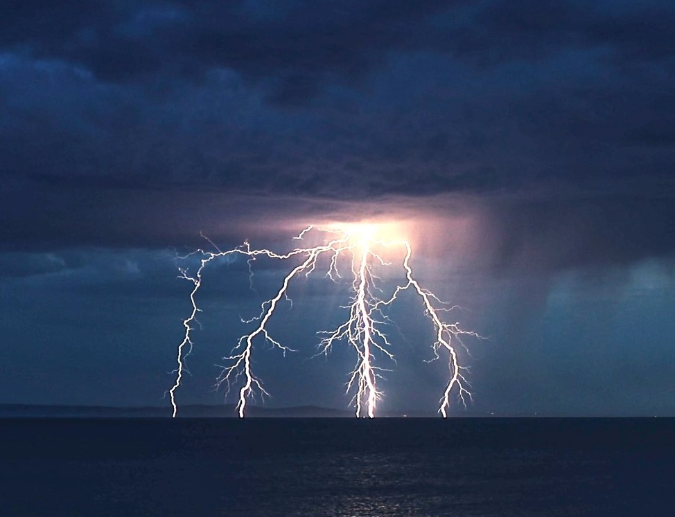 A stunning War of the Worlds-like lightning bolt illuminates the UK coast during the hottest day of the year, captured in an awe-inspiring photo by Stephen Jones.