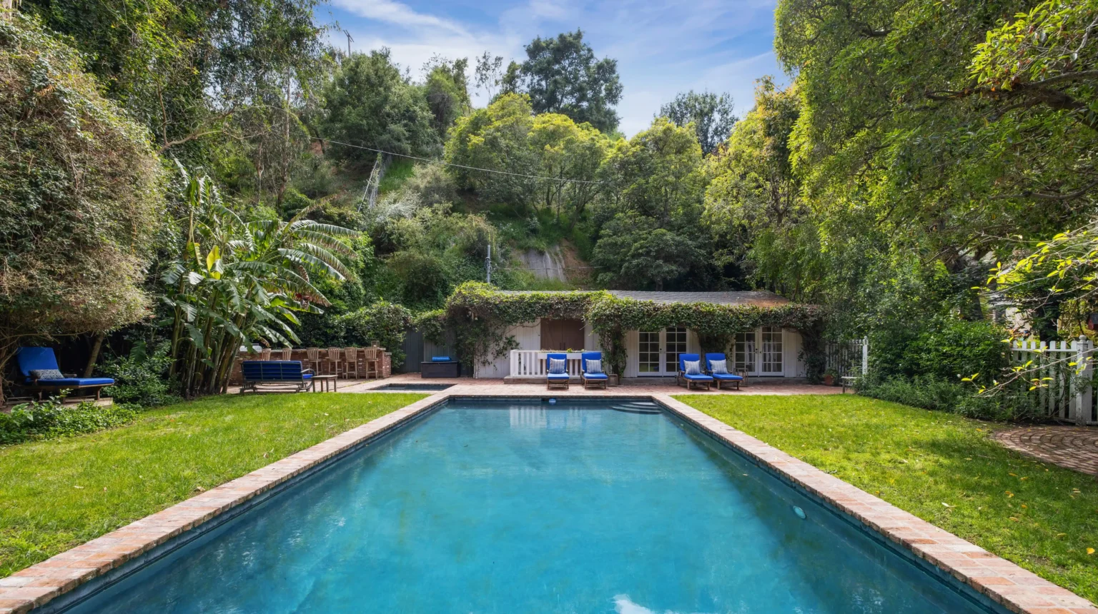 The luxurious $14M estate once owned by Michelle Pfeiffer, nestled in LA's Pacific Palisades, featuring a stunning pool, lush gardens, and celebrity neighbors.