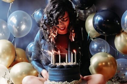 Birthday girl's hair catches fire while blowing out candles during a photoshoot. Despite the scare, she remains calm, and the flames are quickly extinguished. Video goes viral.