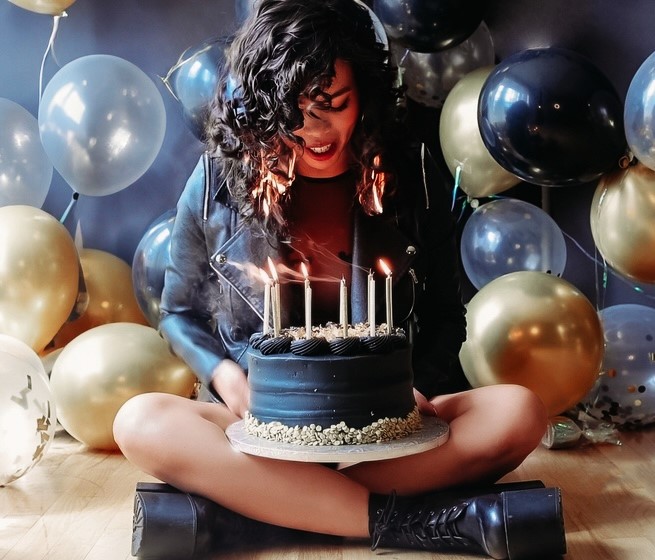 Birthday girl's hair catches fire while blowing out candles during a photoshoot. Despite the scare, she remains calm, and the flames are quickly extinguished. Video goes viral.