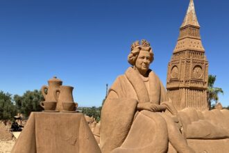 A sand sculpture of Queen Elizabeth II in Portugal remains unchanged nearly two years after her death, with errors on the plaque sparking criticism from tourists.