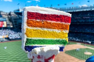 Brits baffled by a £11 gravity-defying freakshake at New York Yankees stadium, featuring a slab of cake on top. Fans question how to eat it and its health impact.