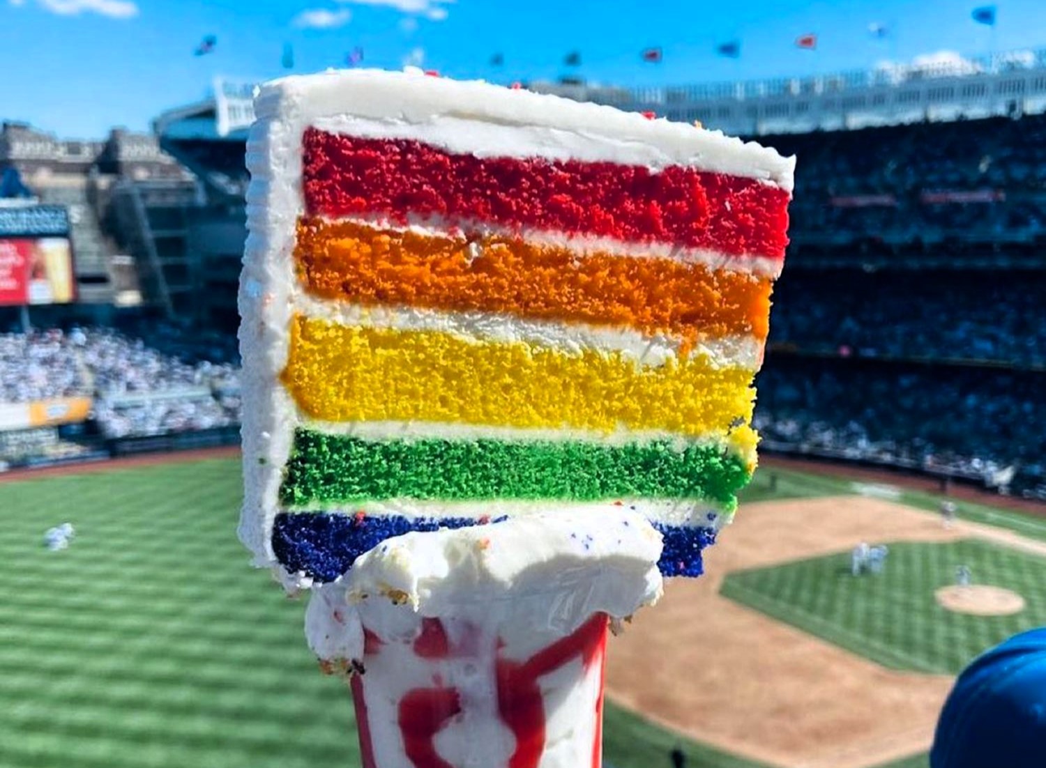 Brits baffled by a £11 gravity-defying freakshake at New York Yankees stadium, featuring a slab of cake on top. Fans question how to eat it and its health impact.