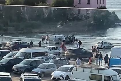 A tourist van got stuck on Polzeath beach in Cornwall as high tide approached, continuing the trend of “idiot season” incidents, with locals rushing to help free the vehicle.