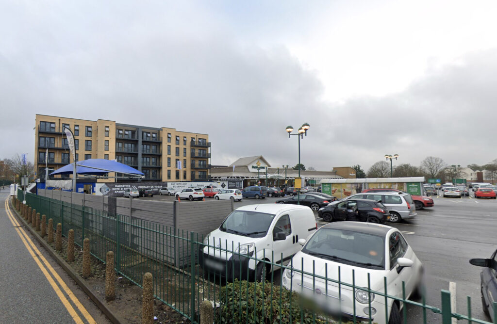 Shoppers stunned as a driver maroons their Toyota Yaris on a bollard outside Morrisons, with spinning wheels and failed attempts to reverse off. Baffled reactions follow.