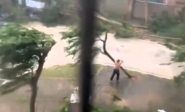 A topless man practices martial arts in the streets during Typhoon Yagi, battling extreme winds before being knocked down. The storm has caused massive damage across Asia.