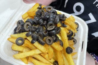 Vegan's bizarre takeaway combo of chips topped with olives shocks social media. Is it genius or gross? See the viral reaction to this unusual Manchester dish!