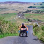 Amputee ex-NHS nurse Lexi Chambers becomes the first person to travel 874 miles from John O'Groats to Land's End in a wheelchair, raising funds for two charitable foundations.