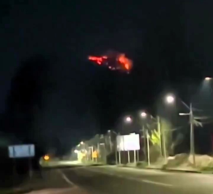 Stunned woman captures mysterious red 'UFO' hovering in Chile's night sky, sparking a viral sensation and social media buzz with theories and reactions.