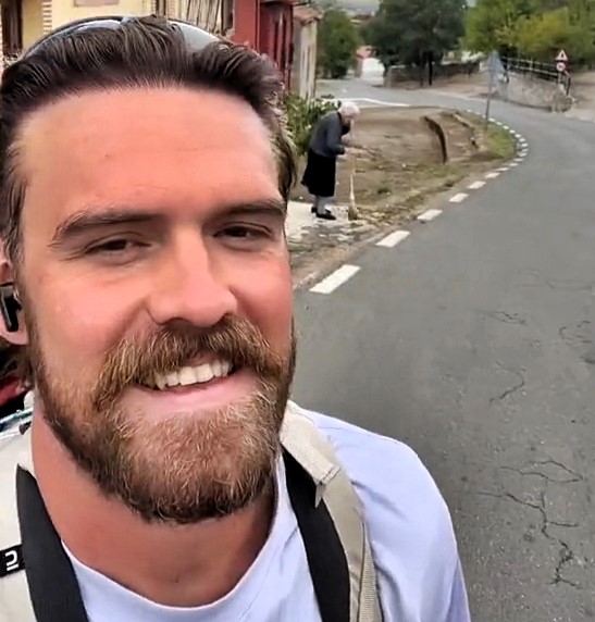 A Brit backpacker, walking across Spain, charms locals by seeking adoption from Spanish grandmothers, praising their warmth and kindness along the way.