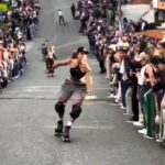 A roller skater loses control at Medellín's Loma Hill Bomb, crashing into spectators and causing laughter-filled chaos in the thrilling biannual skating event.