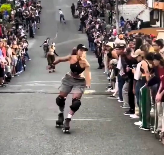 A roller skater loses control at Medellín's Loma Hill Bomb, crashing into spectators and causing laughter-filled chaos in the thrilling biannual skating event.