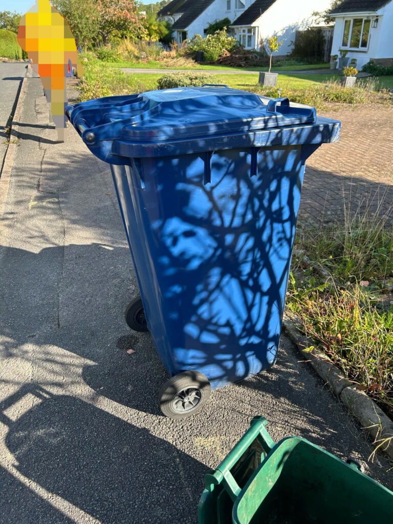 A baffled couple spotted Vladimir Putin's face on a recycling bin, formed by shadows from nearby trees. The uncanny likeness has left friends joking about the eerie sight.