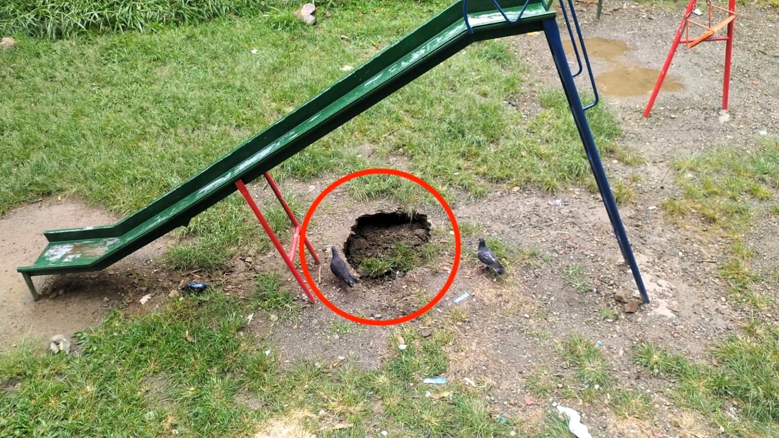 A sinkhole opens under a playground slide in Medellín, Colombia, prompting parents to evacuate children and demand urgent action from authorities to prevent potential accidents.