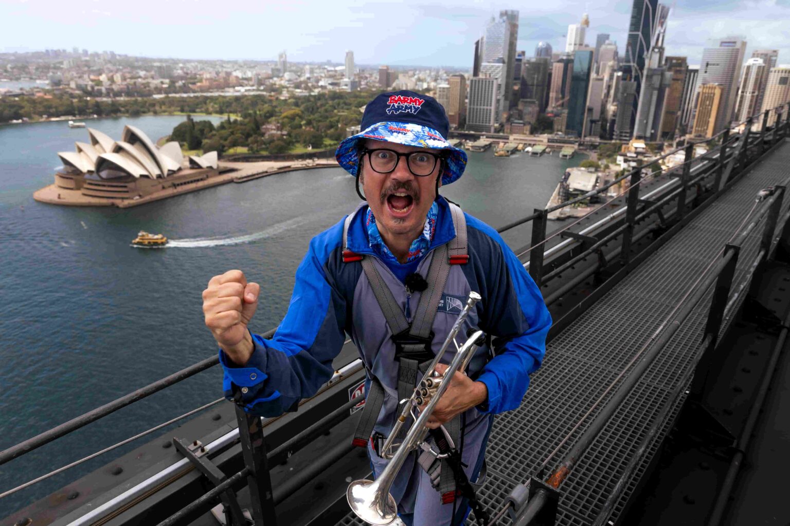 Barmy Army trumpeter Simon Finch sparks Ashes excitement atop Sydney Harbour Bridge, marking one year until England vs Australia 2025 series. Plan your trip now!