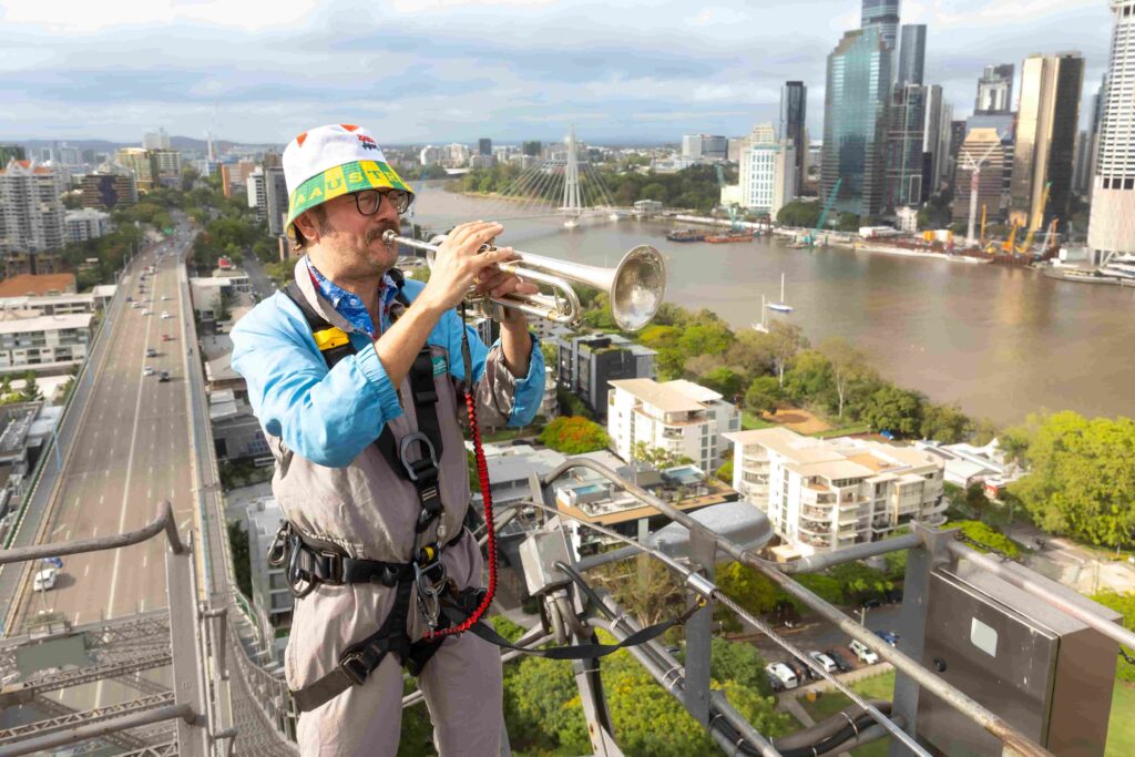 Barmy Army trumpeter Simon Finch sparks Ashes excitement atop Sydney Harbour Bridge, marking one year until England vs Australia 2025 series. Plan your trip now!