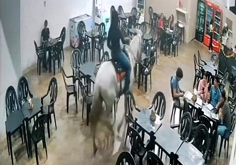 A "drunk" woman shocks diners by riding a horse into a Brazilian snack bar, captured on video. Owner sees humor, and the viral moment brings a business boom.