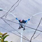 Bizarre rescue in Chile: A man found napping atop a lamp post in Iquique is safely brought down by firefighters, leaving stunned locals and traffic in disbelief.