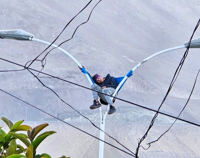 Bizarre rescue in Chile: A man found napping atop a lamp post in Iquique is safely brought down by firefighters, leaving stunned locals and traffic in disbelief.