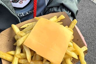 England fan slams Wembley Stadium snack after receiving bland chips with an unmelted cheese slice, sparking outrage over the disappointing pre-match food.