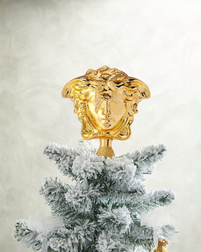 Versace is selling luxury Christmas tree toppers for up to £495, featuring Medusa and coin designs in glittery gold glass, sparking buzz over the festive splurge trend.