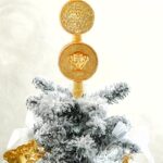 Versace is selling luxury Christmas tree toppers for up to £495, featuring Medusa and coin designs in glittery gold glass, sparking buzz over the festive splurge trend.