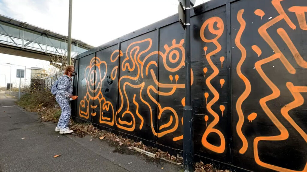 Graffiti artist Mr Doodle creates a stunning 660ft mural in Ashford, Kent, transforming hoardings with his signature style in just one day, sparking local excitement and selfies.