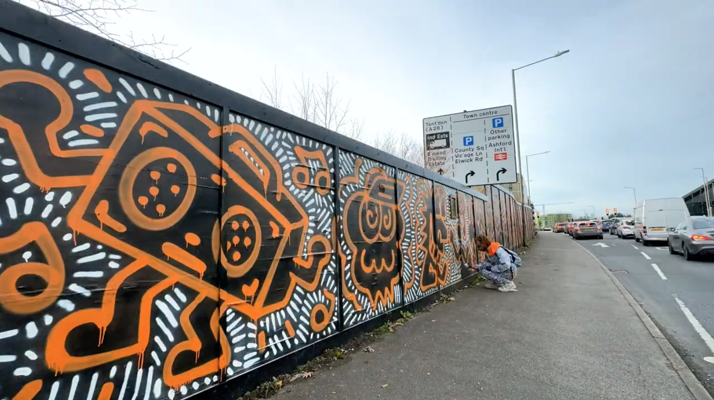 Graffiti artist Mr Doodle creates a stunning 660ft mural in Ashford, Kent, transforming hoardings with his signature style in just one day, sparking local excitement and selfies.