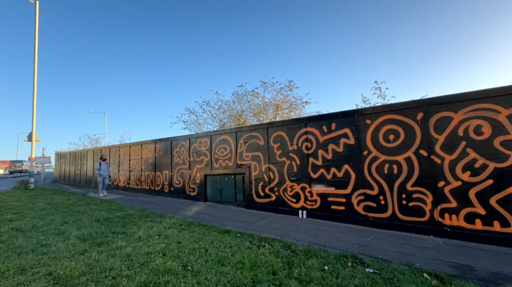 Graffiti artist Mr Doodle creates a stunning 660ft mural in Ashford, Kent, transforming hoardings with his signature style in just one day, sparking local excitement and selfies.