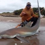 A fisherman in Argentina reeled in a massive 200lb copper shark using a fishing rod, later releasing it back into the sea. Watch the thrilling catch that went viral online!