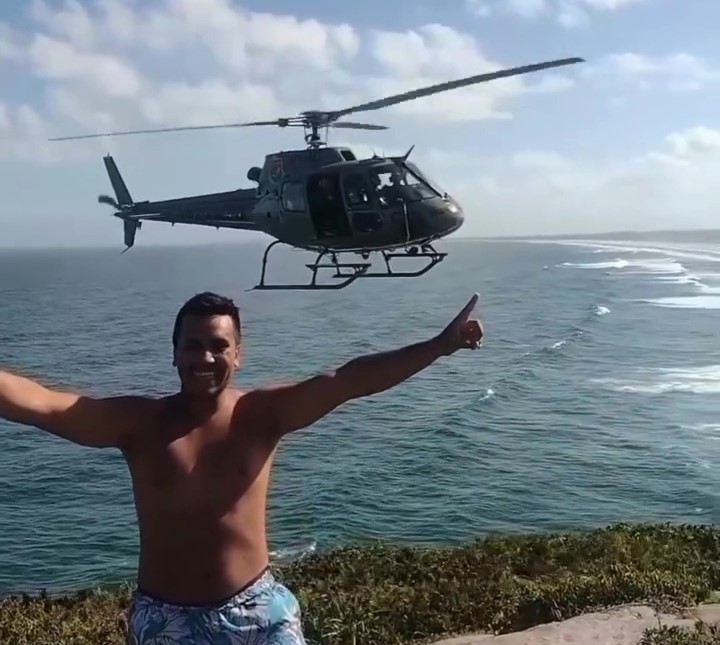 Helicopter pilot's kind gesture goes viral as he pauses mid-flight for a tourist's selfie, creating an unforgettable moment over Itapirubá Beach in Brazil.