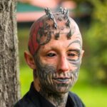 A body modification enthusiast, transforming into a ‘reptilian,’ gets silicone implants in his skull to achieve a cohesive lizard-inspired look, sparking mixed reactions.