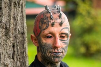 A body modification enthusiast, transforming into a ‘reptilian,’ gets silicone implants in his skull to achieve a cohesive lizard-inspired look, sparking mixed reactions.