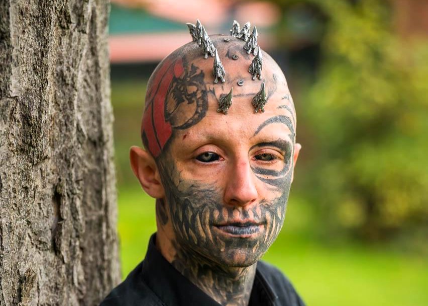 A body modification enthusiast, transforming into a ‘reptilian,’ gets silicone implants in his skull to achieve a cohesive lizard-inspired look, sparking mixed reactions.