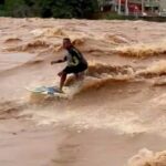 A daring surfer rode the swollen, rapid-moving Doce River in Brazil after heavy rains. Despite warnings from authorities about extreme dangers, Paulo Guido Coelho embraced the challenge.