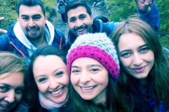 A hiking group selfie goes viral as viewers spot a mysterious face lurking between friends. Is it a ghost, prank, or pareidolia? Discover the chilling viral photo!